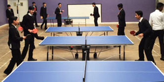 School children playing table tennis on an indoor table provided by Table Tennis Tables
