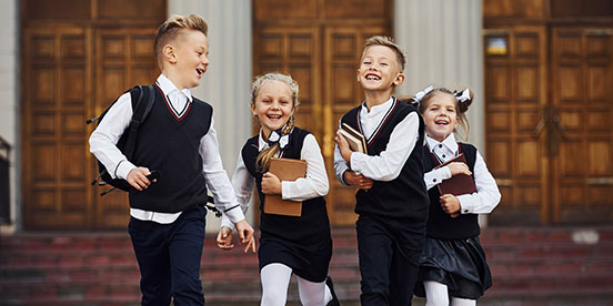 Image of happy primary school kids running 